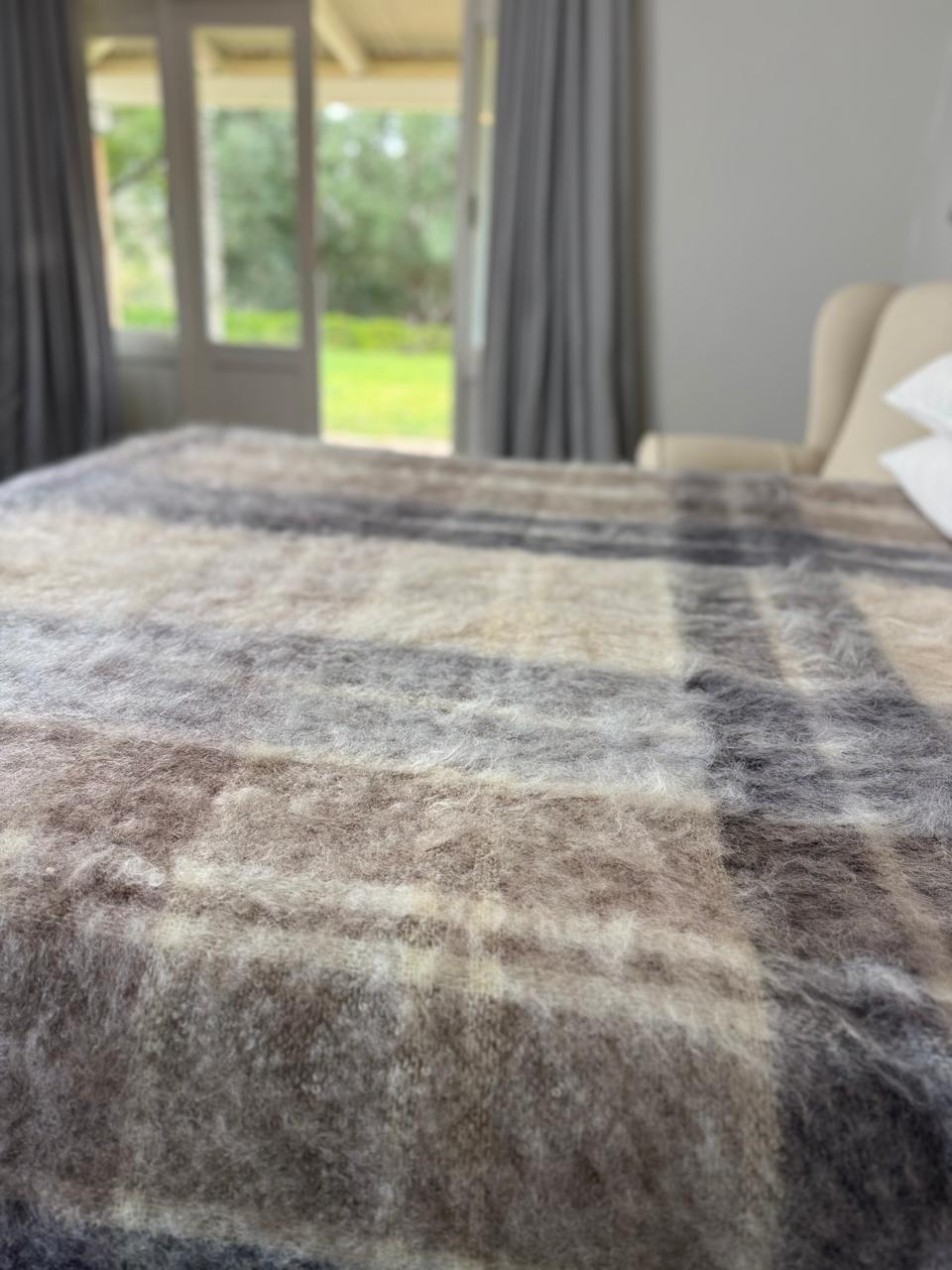 Plaid blanket on a bed with a blurred background